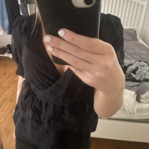 Svart blus - Så snygg svart blus med volang detaljer, lite skrynklig på bilderna (försvinner när man använt ett tag)