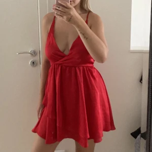 Röd omlottklänning i satin - Fin röd omlottklänning i satin. Från Linn Ahlborg x NA-KD. Använd en gång. Storlek 36. 