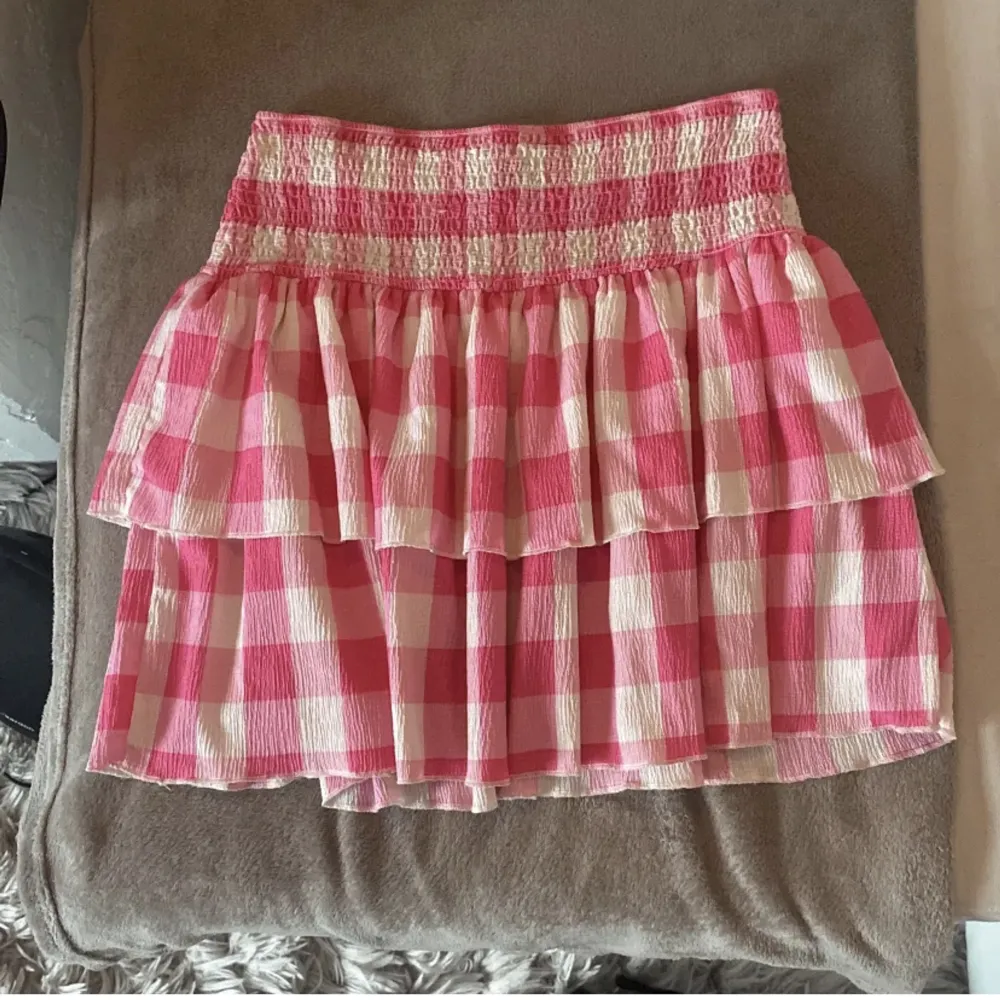 Söt rosa volang kjol i fint skick, använd fåtal gånger, den är även väldigt fin som topp💕. Kjolar.