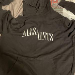 Svart hoodie från AllSaints. I en mer oversized fit. Är 178 cm och bär en storlek S. Den är använd men har mycket kvar att ge.   Nypris runt 1300kr
