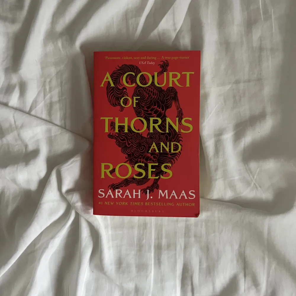 A court of thorns and roses av Sarah j maas på engelska. Lite skrynklig rygg, paperback.. Övrigt.