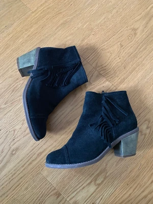Boots i mocka med fransar - Fina låga boots i mocka med fransar på sidan, i bra skick, inga skador eller slitningar. Lagom hör klack