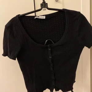 Svart t-shirt  - Svart topp med knappar, använd några gånger