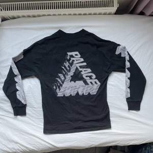 Palace Sweatshirt - En riktigt fet Palace Sweatshirt i svart färg. Den är i väldigt bra skick, inga defekter. Stor vanlig palace logga på ryggen, en liten på högra bröstet, ”palace” på ärmarna. Storlek S men funkar på mig som är M/L. Priset diskuterbart. Läs min bio