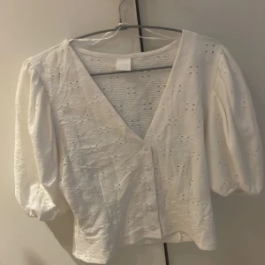 Vit topp - Säljer denna vita topp som har som broderat mönster ifrån hm i storlek S