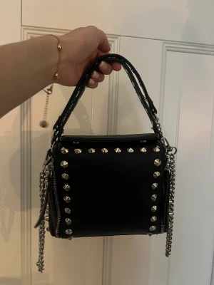 Nit väska - En väska med nitar från zara. Varit väldigt populär och finns ej att köpa. Nästintill oanvänd och jättebra skick säljs då den inte är min stil💞 frakt inräknad i priset