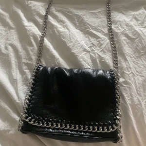 Tiamo väska  - Säljer denna snygga väska som är i väldigt bra skick. Väskan har ett innerfack med dragkedja och två små fack och ett fack med dragkedja bak på väskan, köpte den för 499kr, pris kan diskuteras💓