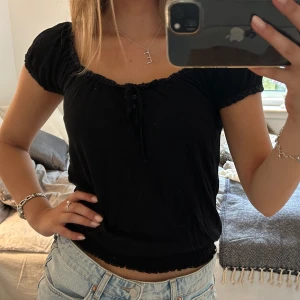 Svart blus  - Svart blus i luftigt och strechigt bomullstyg med söta detaljer! Köparen står för frakten :)