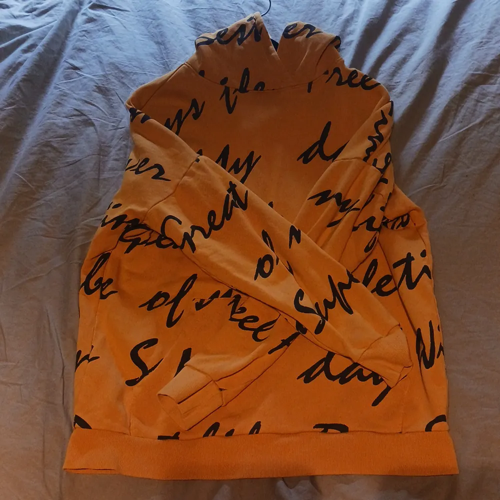 En gul/orange hoodie. Hoodies.