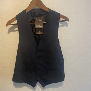 Kostym väst Oscar Jacobsson - Oscar Jacobsson kostym väst, marin blå, storlek 46, helt oanvänd, med prislapp, nypris 2000kr. 