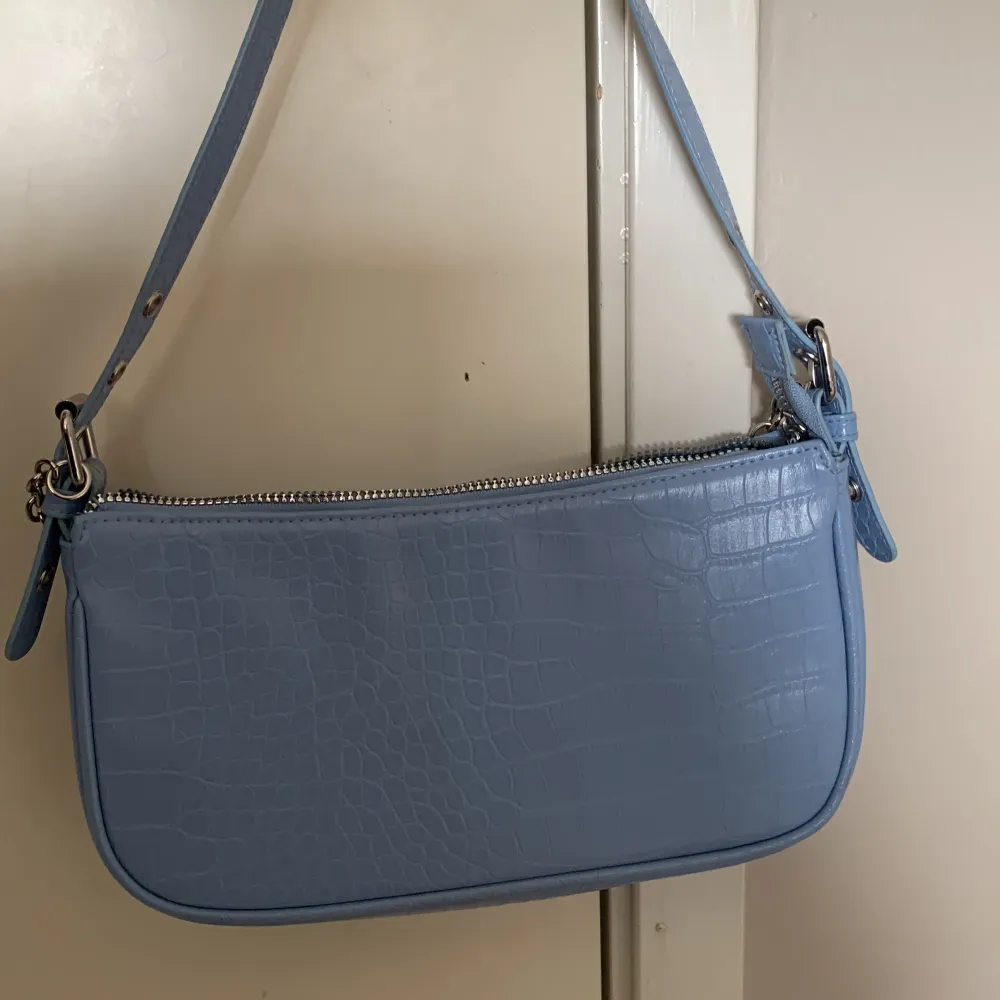 En blå handväska med orm mönster, kedjan går att ta av eller stoppa in! Jättebra skick. Väskor.