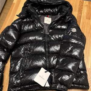 En helt ny moncler maya jacka som är perfekt till vintern som håller dig varm, aldrig använt den, super bra skick och den e jävligt snygg. men tyvärr slängt packetet den kom i.