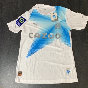Marseille kit fotbollströja storlek L - Säljer en helt ny Marseille tröja storlek L, spelar version så den är tajt, mer som en M i storlek. Med liga patch 
