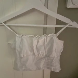 Vit topp - Säljer denna vita topp från HM som använts några gånger och som är i väldigt fint skick!! 