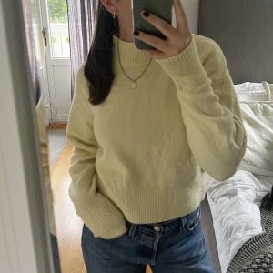 Gul stickad tröja - Stickdtröja i en superfin gul färg. Är lite högre i halsen samt lite kortare i modellen. Är från & other stories i storleken xs, men är mycket stretchig. Den är använd och har blivit nopprig.