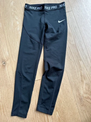Nike PRO träningsbyxor/tights stl 146 - Klassiska Nike PRO träningstights storlek 146. Lätt använda och i jättefint skick. Inga hål, inga fläckar. 
