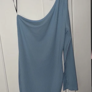 Enarmad klänning Blå - Enarmad blå klänning ifrån SHEIN. Tajt och kort modell som formar sig efter dig. Armen blir bredare längre ut. Oanvänd 