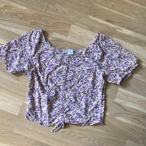 Blommigblus  - Blommig lilla gul blus använd en gång 