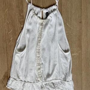 Linne - Tunt vitt linne med spets och liten ”volang” längst ner. Inte genomskinlig. 