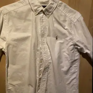 Vit Ralph Lauren skjorta i storleken 14Y. Använd men i fint skick. Dvs inga fläckar eller hål. Nypris ca 1000. Mitt pris 200.