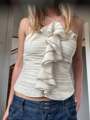 Topp med volang  - Topp med volang. Dragkedja på sidan som ej syns. Bra skick! Cremevit färg. Som en storlek XS-S