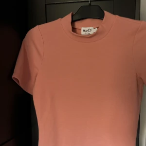 Nakd tröja - Rosa ribbad t shirt från NAKD med fin nacke. Inte använd en enda gång då den ej passar mig.