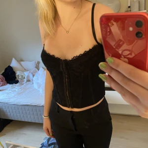 Spets korsett - Svart snygg korsett topp med knäppning på framsidan, storlek s 