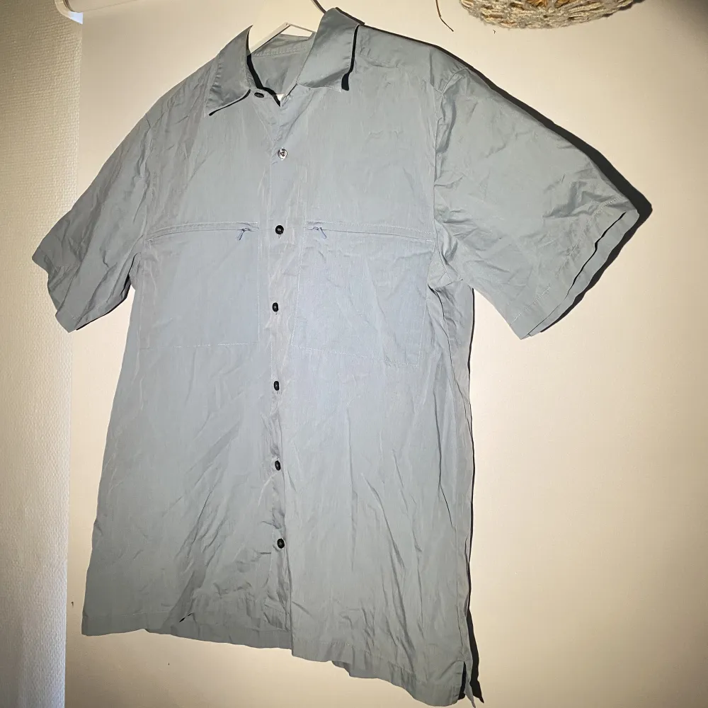 Hej, säljer en kortärmad skjorta i grå/blå färg. Den är i väldigt bra skick. Storlek Large och True To Size. Perfekt inför sommaren. Säljer billigt. Hör av dig vid frågor.. Skjortor.