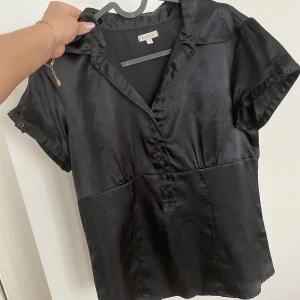 Fin  blus -  vardaglig men även lite finare svart, glansig t-shorts blus!   