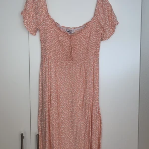 Blommig kortklänning  - Peachfärgad blommig kortklänning😊