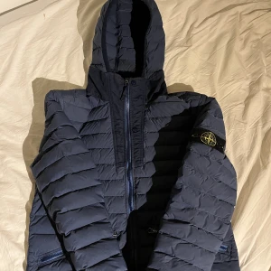 Stone island jacka  - Blå stone island dunjacka Bra skick  Storlek l fits medium   