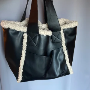 Totebag Carin Wester  - En rymlig totebag från Carin Wester som är använd fåtal gånger. Fake-läder på utsidan i svart på utsidan och beige Teddy på insidan. Köparen står för frakten 🤍