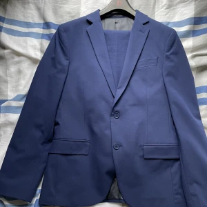 Kostym! - Säljer nu min Mörkblåa kostym från dressman då den blivit för liten! Använd 3ggr så inga tydliga tecken på användning alls. Nypris 2400kr! Byxorna är storlek 30/30 men och kavajen är storlek 48! Den passar någon som är runt 170cm! Hör av er vid frågor!