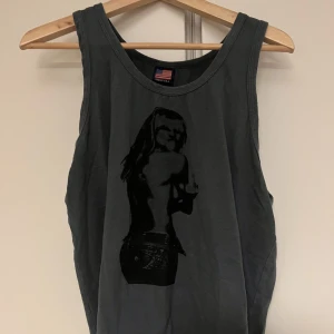 tank top med tryck - en olivgrön tank top med en tjej som pekar mittenfingret (tror det är Britney Spears?) oversized och comfy