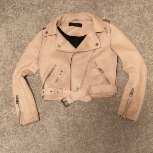 Bikerjacka rosa - En supersnygg bikerjacka i mockaaktigt material och i en fin ljusrosa färg. I storlek XS från Zara basic. (har en liten fläck vid skärpet, bild 2)