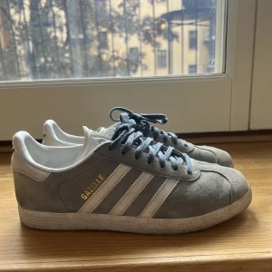 Adidas Gazelle - Säljer mina ljusblå adidas gazelle! Storlek 38 2/3. Använda en del men fortfarande fint skick, går att fixa till bättre.