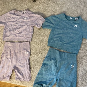 Träningsset shorts/tshirt - Säljer två träningsset. Ett turkos/blått & ett ljuslila. Det lila är lite skrynkligt då det legat i en låda bara, men båda är i väldigt bra skick.  100kr för ett set eller 150kr för båda. (Säljer top & byxa tillsammans) alla delar är i storlek xs/s