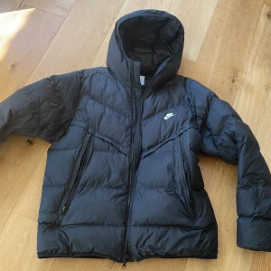 Svart Nike jacka  - Svart Nike jacka passar för alla väder hade den i vintras och den höll mig varm i minus 20. Size L. Nyskick perfekt till vintern