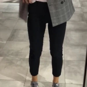 Ankellånga slacks från H&M storlek 34 - Märke: H&M Vad: Ankellånga slacks, dragkedja i sidan Storlek: 34 Upplevd i storlek: Stora, passar mig som brukar ha 36 Färg:  Marinblå med kritstreckMaterial: Vet ej då jag klippt bort lappen, men skulle chansa på bomull & elastan Skick: Inget att anmärka