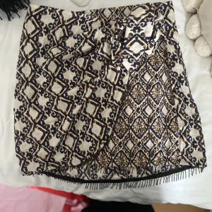 Mini kjol - Mönstrad kort kjol med strassdetalj. Den är från Zara. Storlek XS 