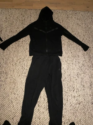 Nike tech tracksuit  - Jag fick denna dressen i julklapp i vintras, dock har jag bara använt den i ungefär 2-3 månader eftersom jag växte ur den väldigt snabbt. Nu har den bara legat i garderoben ett tag och vill få bort den. Färgen är i svart. Storlek Small/158-170