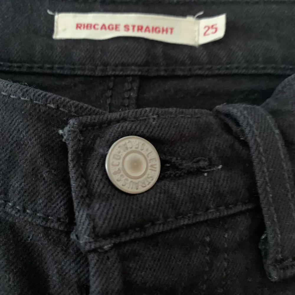 Säljer mina svarta Levis Ribcage jeans i svart, ankle length. I bra skick, färgen är något urtvättad men går att färga om med lite svart tygförg om man inte gillar det lite ljusare partierna!. Jeans & Byxor.
