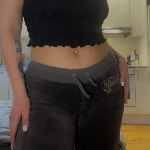 Retro juicycouture mjukisbyxor  - Fina retro lågmidjade juicycouture byxor i färgen brun. Färgen stämmer överens med första bilden. Inga anmärkningar förutom att snörena är avklippta, se bild 2. Storlek S men passar även mig som har M, sitter lite tajtare då såklart. Innerbenslängd ca 78c