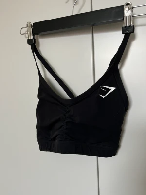 Gymshark sport-bh  - Snygg sport-bh från Gymshark, modellen heter Ruched Sports bra. Snygg rygg och ger bra stöd. Fint använt skick! 