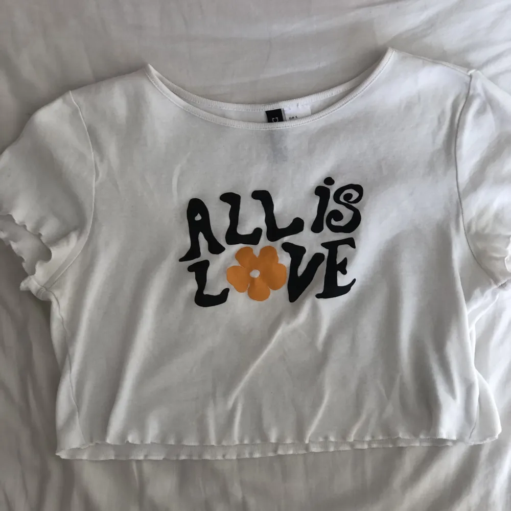 Supergulliga liten tank top/babytee från HM som jag köpte ett tag sedan, säljer den pga den är lite liten för mig. Passformen är dock gullig oavsett! Motivet är ”all is love” så kan tänka mig att den är lite 70-tals inspirerad. Inga defekter. Frågor=skriv. Toppar.