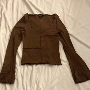 Brun långarmad tröja - Köpt för ca 1 år sedan, stretchig och stor för sin storlek! Använd ytterst sällan, säljer för att det inte är min stil längre. Frakten står köparen för!