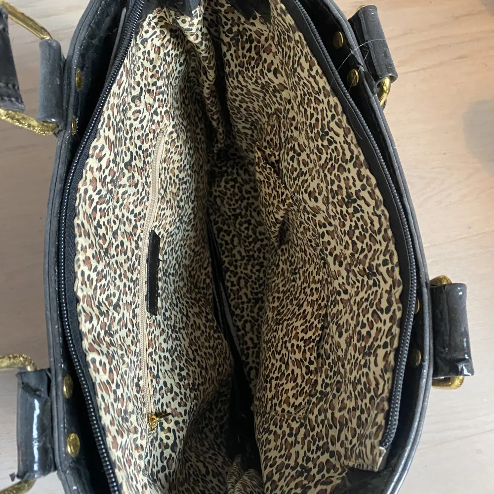 Super fin lack väska med leopard print, som rymmer massor! Lacket håller däremot på att lossna på både axelbanden och ”sidorna” och därför blir det som små svarta korn efter väskan. Det finns ett annat axelband i väskan om man vill ha det istället <3 . Väskor.