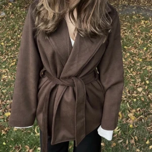 Brun kappa - Lånad bild! Säljer mim bruna kappa jag köpte här på plick då den inte satt som förväntat på mig. Tidigare ägaren har använt den en gång och jag har enbart provat den. Är från NA-KD. 