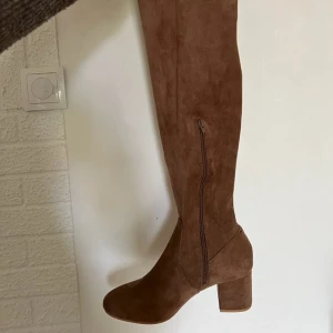 Nya klackar - Klackar med låg och bred klack. Räcker precis till/ovanför knäna. Brun mockaimitation. Använda 1 kväll, jättebra skick. Nypris:700kr Pris går att diskutera