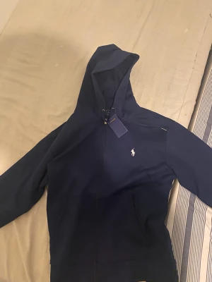 Ralph floren zip up - En helt ny Ralph floren zip up i perfekt skick och sitter jätte skönt på, storlek M. Fick den i present en äkta kostar 1600 kronor. Pris kan diskuteras.